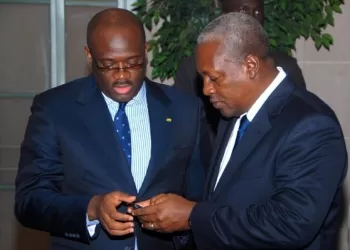 Stan Dogbe (L) interacts with former President John Mahama